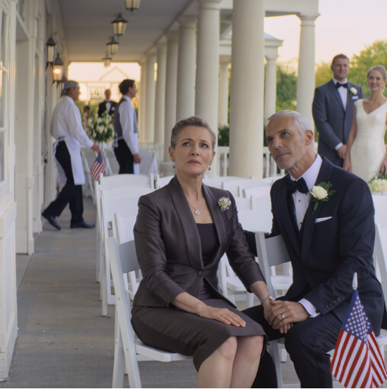 At my son’s luxury wedding, they put me in row 14 right beside the service area. The bride leaned in and whispered, ‘Please… don’t make us look bad today.’ Then a man in a black suit sat next to me and murmured, ‘Let’s pretend we came together.’ When my son looked down and saw us, his face went pale.